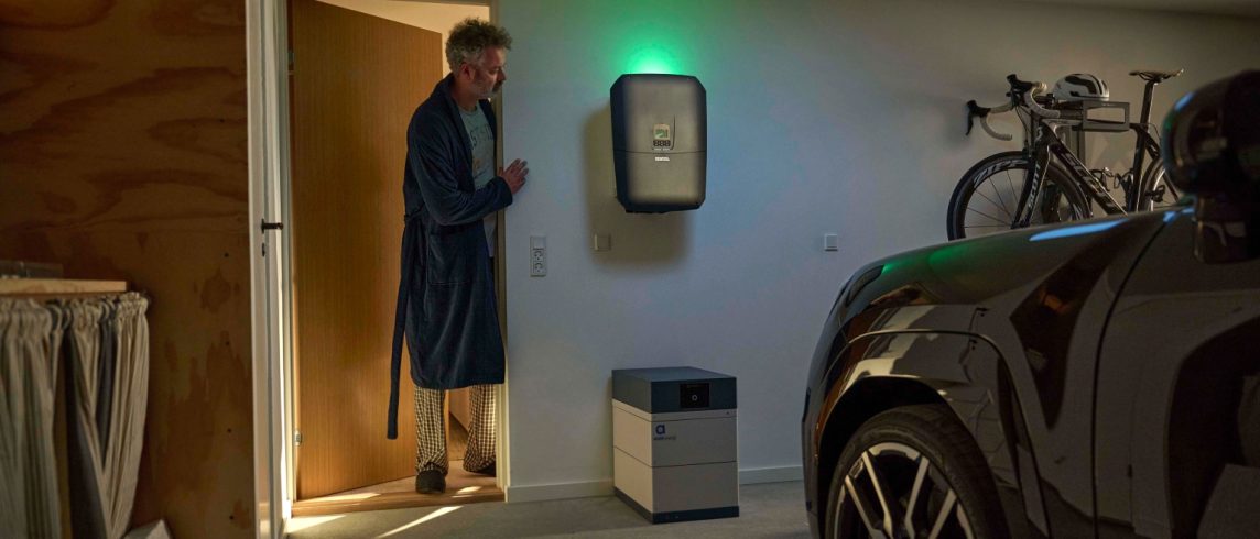 Mand kigger til sit hjemmebatteri fra Andel Energi i garagen.